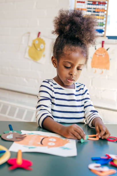 little girl in preschool making artart